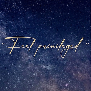 Puede incluir: Un cielo nocturno azul oscuro con una brillante galaxia de la V&iacute;a L&aacute;ctea blanca y una dispersi&oacute;n de estrellas. El texto "Feel privileged." est&aacute; escrito en cursiva dorada.