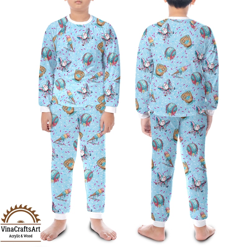 May include: Light blue children's pyjama set featuring a pattern of baseballs, gloves, and ice cream cones. The top and trousers have white trim. The pyjamas are designed for children.