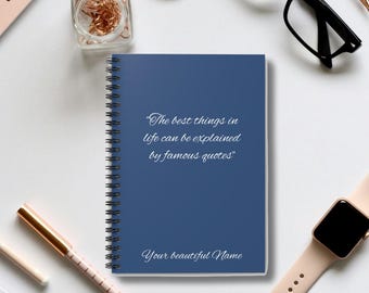 May include: A blue spiral notebook with the quote "The best things in life can be explained by famous quotes" and the text "Your beautiful Name" on the cover.