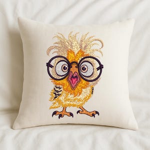 Cream-colored pillow featuring cute owl embroidery design with large glasses, placed on a soft bed – perfect for cozy home decor or nursery gifts in the USA and Europe.