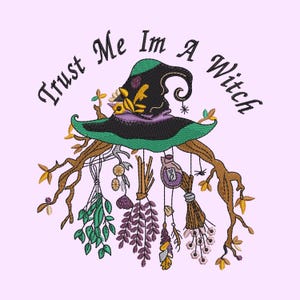 May include: An embroidery design featuring a black and green witch hat centered above brown tree branches. Hanging from the branches are bundles of green and purple herbs, a small potion bottle, and a spider. The text reads Trust Me Im A Witch.