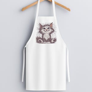 White kitchen apron with fluffy cat embroidery design hanging on wooden hanger, ideal for pet lovers, gift makers, and embroidery enthusiasts.