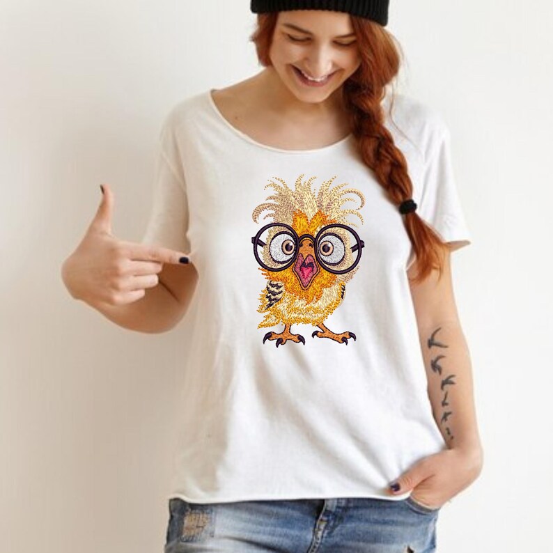 Young woman wearing white t-shirt with cute baby owl embroidery design featuring funny glasses, perfect for machine embroidery lovers and gift ideas in the USA.