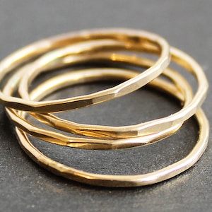May include: Four gold stacking rings with a hammered finish.