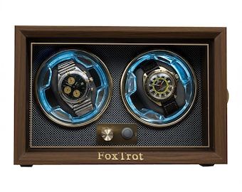 May include: A rectangular wooden watch winder box with the text FoxTrot printed on the front. It features two circular compartments with blue LED lighting, each holding a wristwatch. A metallic control knob and a power button are centred below.
