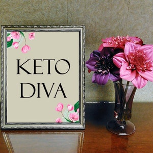 Puede incluir: Una imagen enmarcada en plata con un fondo beige y flores rosas. El texto "KETO DIVA" est&aacute; impreso en negro.