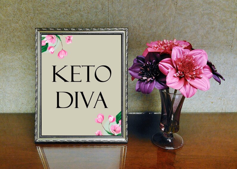 Puede incluir: Una imagen enmarcada en plata con un fondo beige y flores rosas. El texto "KETO DIVA" est&aacute; impreso en negro.