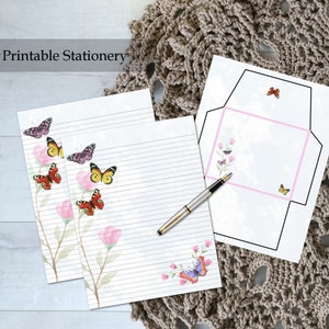 May include: Printable stationery set with lined paper and an envelope featuring a watercolor design of butterflies and flowers. The text "Printable Stationery" is at the top of the image.