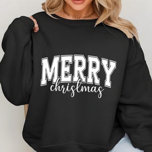 May include: Black crew neck sweatshirt with the words "MERRY christmas" printed in white. The word "MERRY" is in a bold, block letter font, while "christmas" is in a cursive script. The sweatshirt is a casual, festive garment.