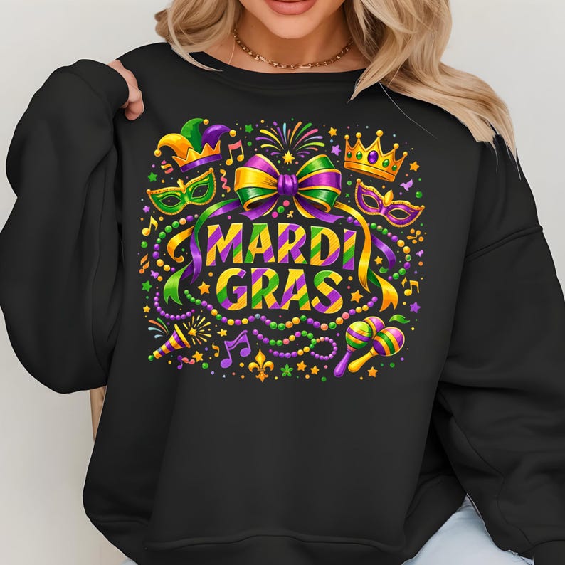 May include: Black sweatshirt with a colorful Mardi Gras design. The graphic includes the words "Mardi Gras" in yellow and purple, along with masks, musical notes, and a crown. The design features green, purple, and gold accents.
