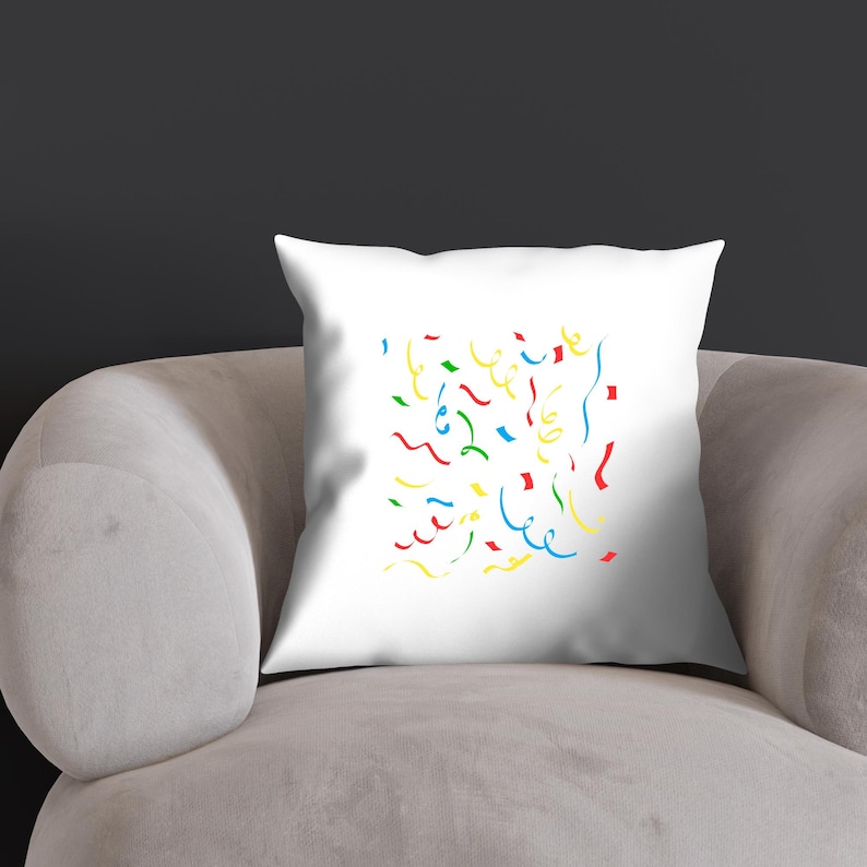 K&ouml;nnte beinhalten: Ein wei&szlig;es Kissen mit einem bunten Konfetti-Design. Das Konfetti besteht aus roten, gelben, blauen und gr&uuml;nen Wellenlinien.