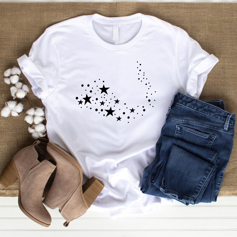 K&ouml;nnte beinhalten: Wei&szlig;es T-Shirt mit einem schwarzen Design aus einem Stern- und Punktmuster.