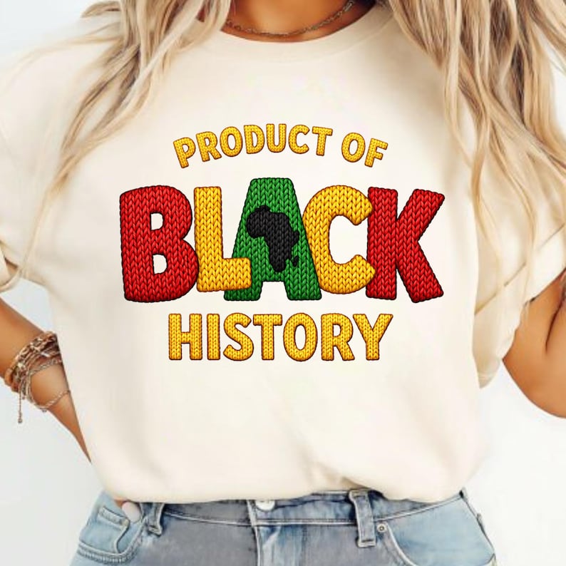 K&ouml;nnte beinhalten: Cremefarbenes T-Shirt mit dem Text "PRODUCT OF BLACK HISTORY" in Gelb, Rot und Gr&uuml;n. Das Wort "BLACK" zeigt eine schwarze Silhouette des afrikanischen Kontinents. Das Shirt hat einen Rundhalsausschnitt und kurze &Auml;rmel.