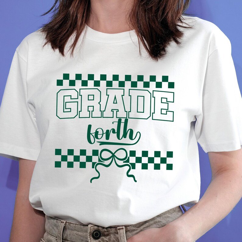 Op de afbeelding: Wit t-shirt met de tekst "GRADE forth" in groene blokletters, omgeven door een groen dambordpatroon. Onder het woord "forth" staat een groen strikdesign.