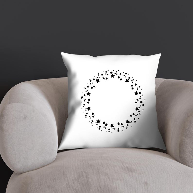 K&ouml;nnte beinhalten: Ein wei&szlig;es Kissen mit einem schwarzen Sternenmuster. Die Sterne sind in einem Kreis um einen leeren Raum in der Mitte des Kissens angeordnet.