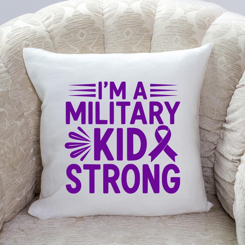 May include: White square pillow with the text "I'M A MILITARY KID STRONG" in purple. The pillow is on a patterned chair. The text includes a ribbon graphic.