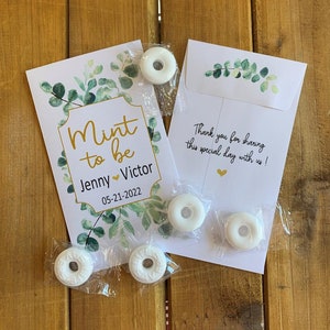 May include: White mint candies in clear plastic bags with a wedding favor tag that says "Mint to be Jenny Victor 05-21-2022" and a thank you card that says "Thank you for sharing this special day with us!"
