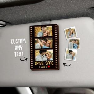 May include: A brown film strip-shaped car visor clip with three photos of a couple. The text "DRIVE SAFE I LOVE U" is at the bottom. Additional photos are to the right. The text "CUSTOM ANY TEXT" is to the left.
