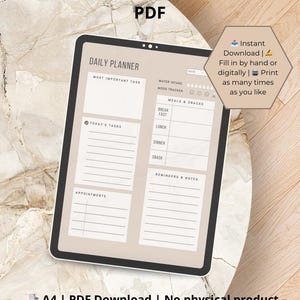 Op de afbeelding: Een digitale tablet met een afdrukbare dagelijkse planner-sjabloon. De planner bevat secties voor een belangrijkste taak, taken van vandaag, afspraken, waterinname, stemmingstracker, maaltijden en snacks, en herinneringen en notities. De tekst "Direct downloaden | Met de hand of digitaal invullen | Zo vaak afdrukken als je wilt" wordt weergegeven in een spraakballon.