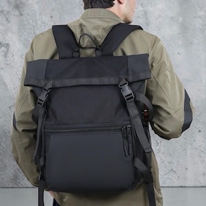 May include: Black backpack with a roll-top closure and adjustable straps. The backpack features a front zippered pocket and side mesh pocket. The bag is made of a durable, water-resistant material, suitable for everyday use.