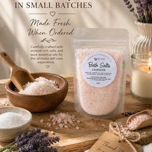 Pu&ograve; includere: Una busta trasparente di sali da bagno alla lavanda con un'etichetta circolare che riporta Bath Salts Lavender, 113g. La busta &egrave; circondata da una ciotola di legno con sale rosa, una ciotolina di sale bianco, un cucchiaio di legno e lavanda.