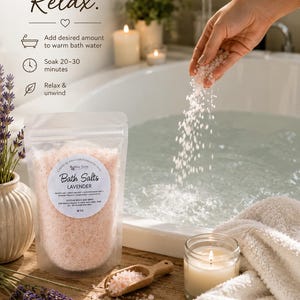 Pu&ograve; includere: Una busta trasparente di sali da bagno alla lavanda rosa con un'etichetta che riporta Bath Salts LAVENDER. Il testo Add. Soak. Relax. &egrave; visibile insieme alle istruzioni. Cristalli di sale rosa vengono versati in una vasca bianca vicino a un cucchiaio di legno.