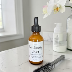 May include: An amber glass bottle with a black dropper cap containing Hair Smoothing Serum by Make Scents by Kim. The label lists a lightweight leave-in formula with Aloe Vera, Argan Oil, Rosemary, Vitamin E, and Pure Essential Oils, 2 oz.