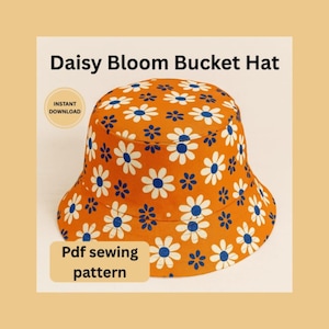 May include: Orange bucket hat with a white daisy and blue center floral pattern. The hat has the text "Daisy Bloom Bucket Hat" and "Pdf sewing pattern". The hat is a downloadable sewing pattern.
