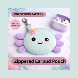 May include: A mint green zippered earbud pouch shaped like an axolotl, with lavender appendages and a small flower accent. The pouch has a smiling face and a silver clasp. The image also includes a pair of white earbuds in a purple case. Text reads "PDF Sewing Pattern" and "Instant Download."