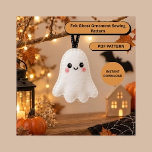 Könnte beinhalten: Ein weißes Filz-Geisterornament mit schwarzen Augen, einem kleinen Lächeln und rosa Wangen, das an einem schwarzen Band hängt. Der Text lautet: Felt Ghost Ornament Sewing Pattern, PDF PATTERN, INSTANT DOWNLOAD. Der Geist hat einen gewellten Rand.