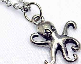 Puede incluir: Un collar de cadena de plata con un colgante de pulpo. El pulpo está detallado con ojos y tentáculos.