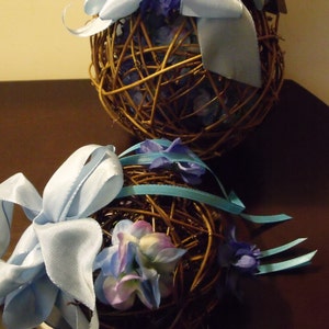 May include: Two decorative twig balls with blue ribbon and blue and purple flowers.