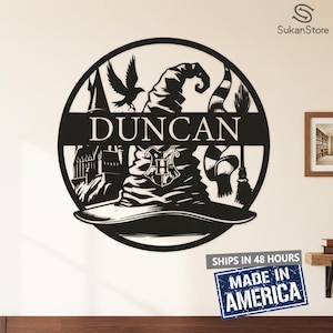 May include: Black metal wall art featuring a wizard hat, a raven, and the name "DUNCAN" in a circular design. Includes a scarf, a broom, and a castle silhouette. The words "MADE IN AMERICA" are visible.