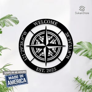 May include: Black metal compass with a white compass rose and the words "WELCOME", "EST. 2025", "121°29′38.0"W" and "38°34′51.8"N" around the perimeter.