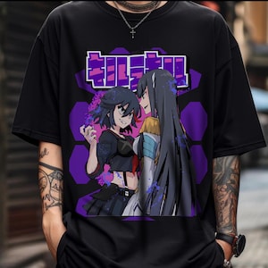 May include: Black t-shirt featuring a vibrant anime graphic. The design showcases two female characters with detailed artwork, set against a purple geometric background. The Japanese text is displayed above the characters.