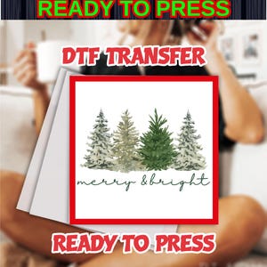 May include: A DTF transfer featuring a watercolor design of four Christmas trees in shades of green and gray, with the words "merry & bright" in a script font. The text "READY TO PRESS" is at the top and bottom.