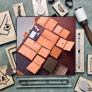 May include: An overhead shot showcases various tan leather wallets and related crafting tools. Several open wallets reveal interior compartments. Wooden die-cut shapes and a mallet are arranged around the wallets, suggesting a leathercrafting theme.
