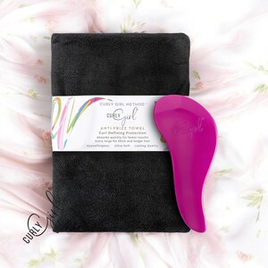 May include: A black microfiber hair towel with the text "CURLY GIRL METHOD™ CURLY girl ANTI-FRIZZ TOWEL Curl Defining Protection Absorbs quickly for faster results Extra large for thick and longer hair Hypoallergenic Ultra Soft Lasting Quality" and a pink hair pick with the text "CURLY girl" on it.