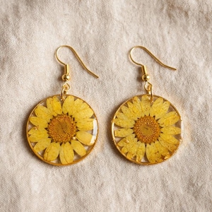 Brincos de argola artesanais em resina com girassóis, flores secas de verdade e folhas esqueletizadas. Joias boho de verão.