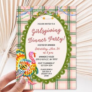 May include: A rectangular invitation card featuring a pink and green plaid background with a central oval frame. The text reads: Girlsgiving Dinner Party! Hosted by Amanda, Saturday, Nov. 24 at 8 pm, Amanda's House, 200 E 45th St, NY 10017.