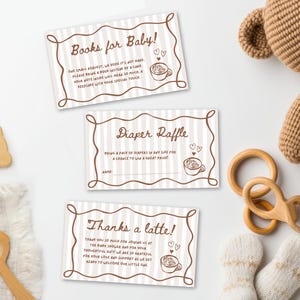 May include: Three baby shower cards with brown text and illustrations on a striped background. The cards read "Books for Baby!", "Diaper Raffle", and "Thanks a latte!". A wooden toy, a teddy bear, and baby socks are also in the image.