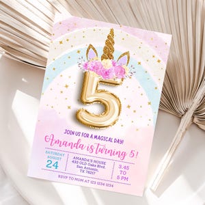 May include: A birthday invitation with a unicorn theme. The invitation features a gold number 5 balloon, a unicorn horn, and floral accents. The text reads "Amanda is turning 5!" and includes event details.