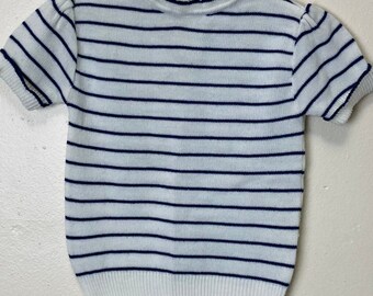 Könnte beinhalten: Weißer Kurzarm-Pullover mit dunkelblauen Streifen und einem Rollkragen.