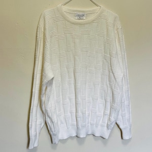 Può includere: Maglione bianco sporco con un motivo a trama intrecciata. Il maglione a girocollo a maniche lunghe è appeso a un'appendiabiti. L'etichetta recita "Christian Dior".