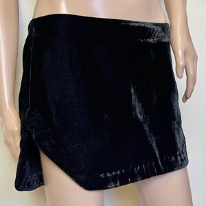 May include: A black velvet mini skirt with a high waist and a slightly asymmetrical hemline.