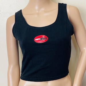 May include: Black crop top tank with a scoop neck and a red and white logo on the front. The tank top is sleeveless and made of a soft material. The logo is oval-shaped and features the text "ESP" and "SPORTS".