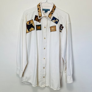 May include: A white long-sleeve button-down shirt with a brown and tan collar and various dog-themed patches. The patches feature dogs, bones, and the text "Faithful Companion".