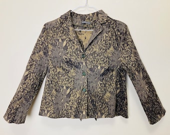 Könnte beinhalten: Ein brauner und beigefarbener gemusterter Blazer mit Kragen und Knopfleiste. Der Blazer hat lange Ärmel und eine lockere Passform.