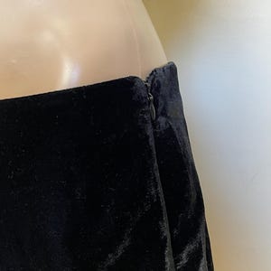 May include: Black velvet skirt with a zipper closure in the back.