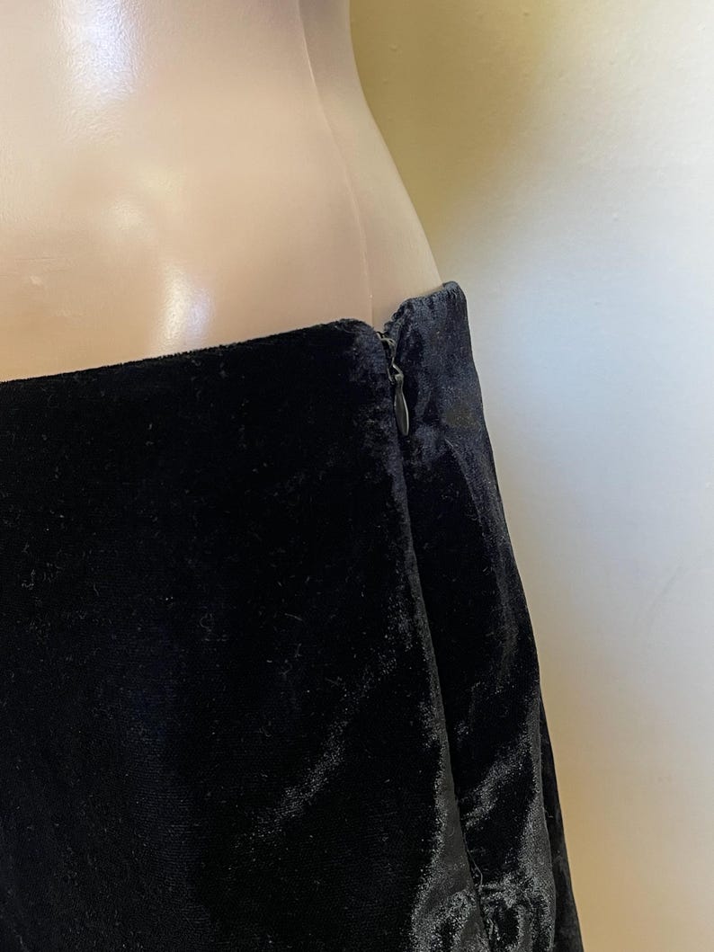 May include: Black velvet skirt with a zipper closure in the back.